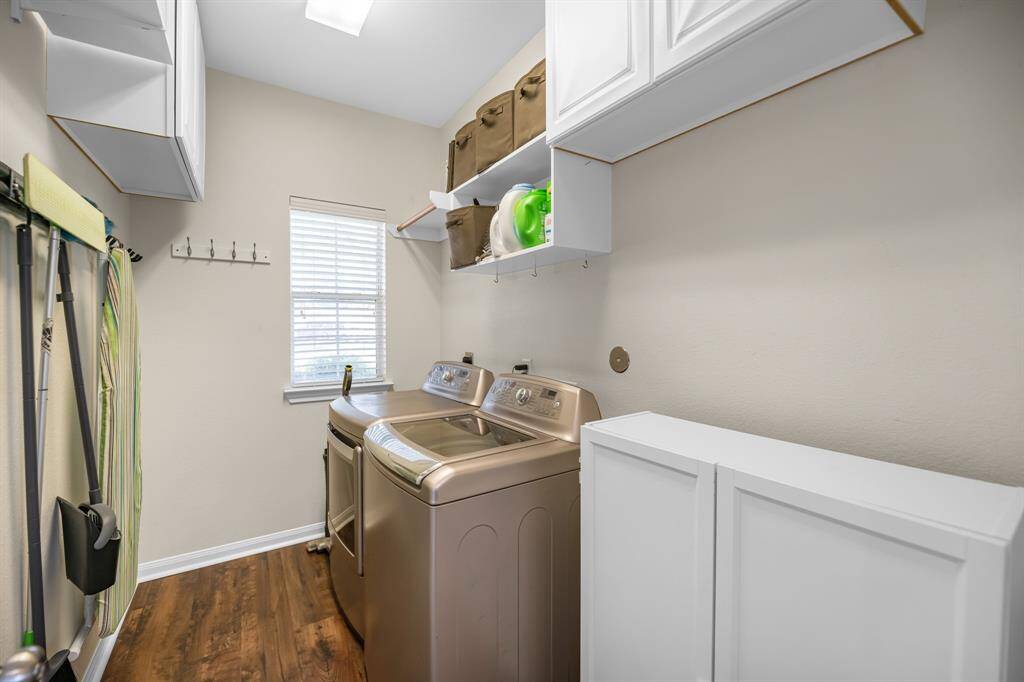 Utility room just off the kitchen with built in cabinets and plenty of space for an additional fridge or freezer.