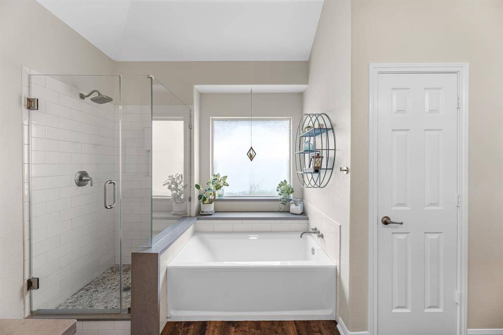 Newly remodeled attached en-suite bathroom with frameless glass shower, subway tile, & soaking tub.