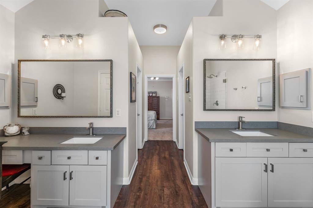 Remodeled dual vanities with framed mirrors, new lighting, and cabinets.