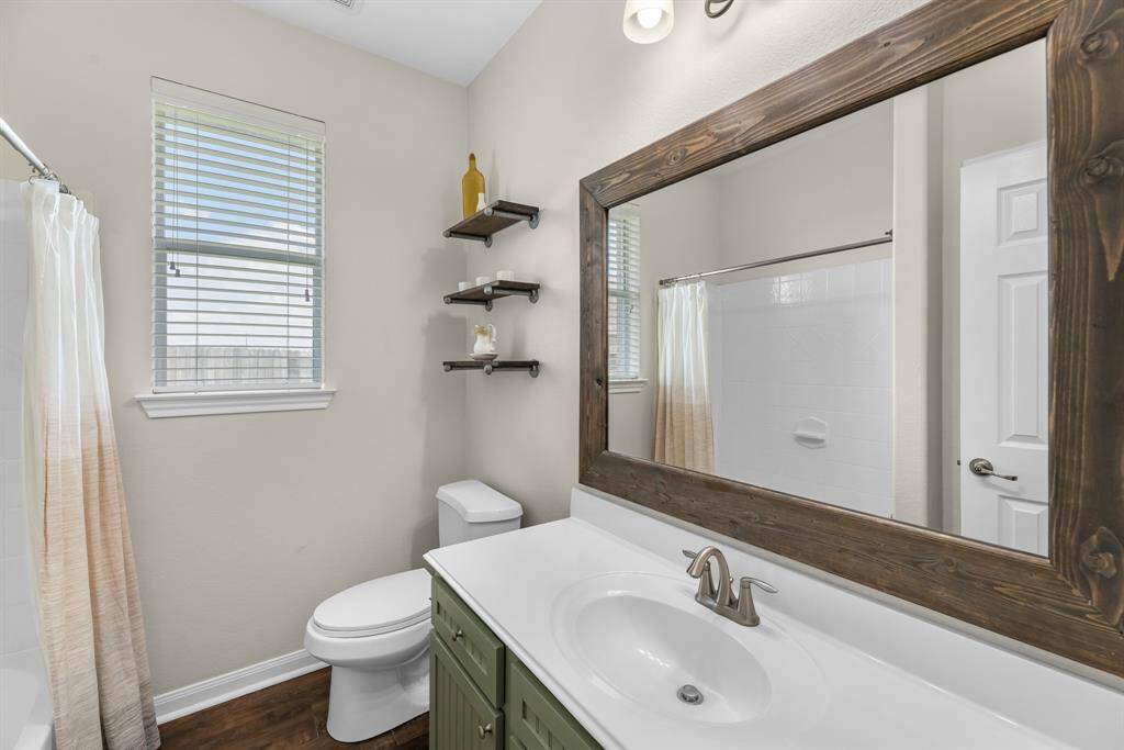 Revamped second bathroom located between second and third bedrooms with framed mirror and refinished cabinet.