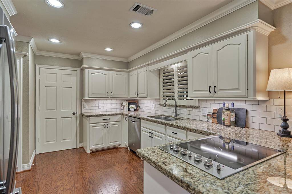 Sleek granite and a double sink offer functionality, while a subway tile backsplash adds a classic touch. Behind the door you'll find a large laundry room with access to the patio & breezeway to the garage.