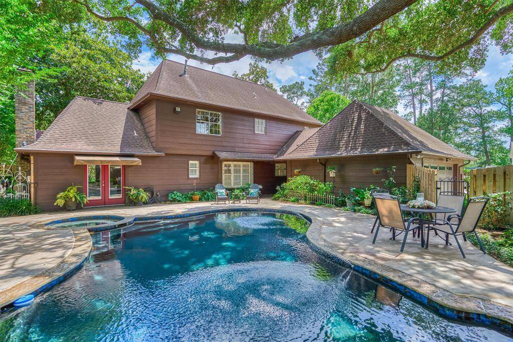 Beautiful, curvy pool surrounded by abundant decking & lush greenery. The soothing exterior complements the serene setting, and a cozy outdoor seating area is perfect for relaxation or entertaining. The graceful oak provides ample shade and enhances tranquility.