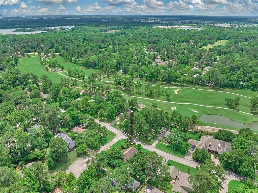 This aerial photo showcases a home located in a lush, tree-filled neighborhood adjacent to the River Plantation Golf Course.