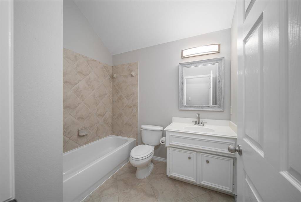 A spacious hall bath features a tub and shower combination.