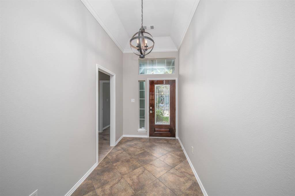 An elegant entryway rests under artistic lighting.