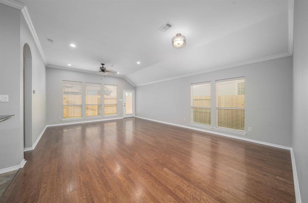 A combination living/ dining room allows for any number of furniture arrangements. The wall of windows in the back overlooks the backyard. Access to the backyard and patio is in the corner.