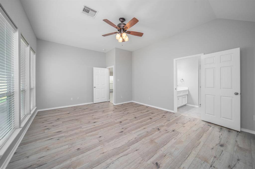 An outstanding primary suite is bathed in cool tones that are the perfect complement to the new floors.