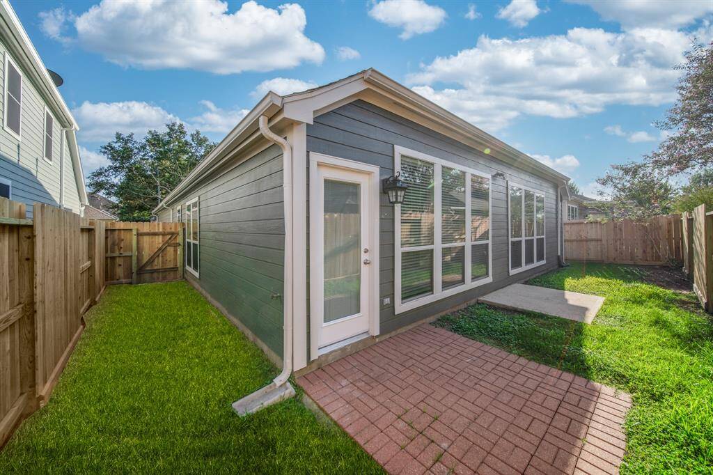 This backyard includes two patio spaces and ample space for some outdoor seating.