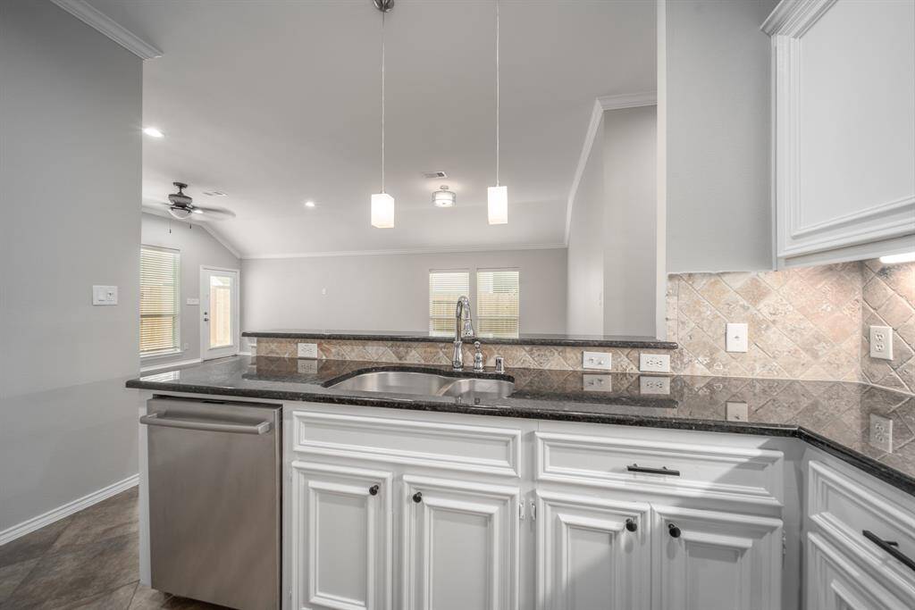 Look out onto a spacious family room from the kitchen. The adjoining spaces make this the ideal home to entertain guests.