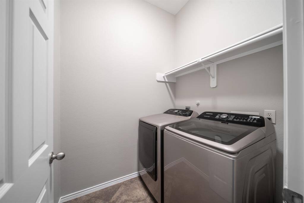 A spacious indoor utility room boasts modern appliances that are included with the home.