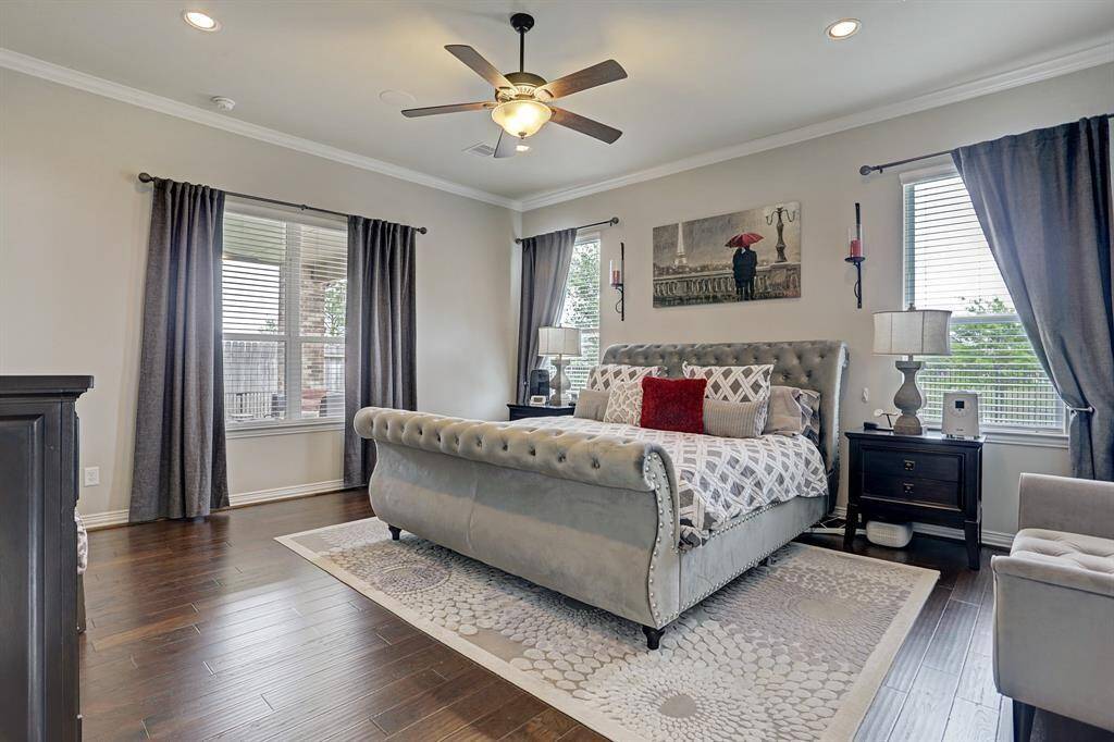 The spacious primary bedroom located on the first floor, offers a serene retreat for the home owners. Hardwood floors, plenty of windows and crown molding all add to the elegance of the room.
