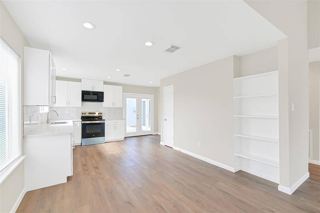 Sunlight pours into the kitchen, highlighting the stainless steel appliances and pristine countertops, making it the perfect place to create culinary delights.