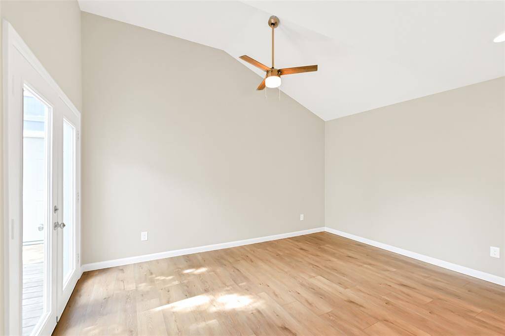This spacious primary bedroom features soaring vaulted ceilings, creating an open and airy atmosphere. Enjoy direct access to the private patio, perfect for morning coffee or evening relaxation.