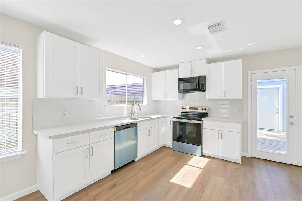 Sunlight pours into the kitchen, highlighting the stainless steel appliances and pristine quartz countertops, making it the perfect place to create culinary delights.