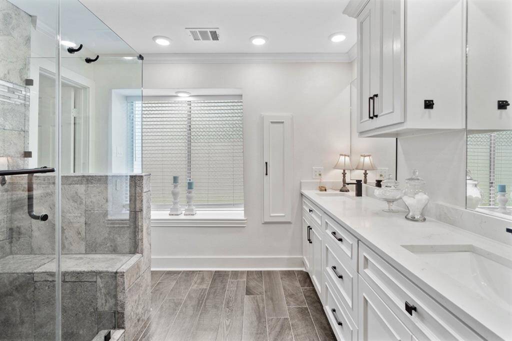 Primary bathroom was remodeled in 2023 and offers glass shower w ceramic tile, bench seat + rain shower head.