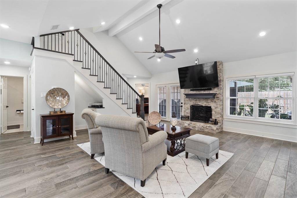 Family room offers cozy fireplace and 36” ceramic wood-looking tile floors throughout the home