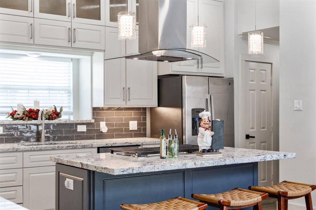 Checkout this island kitchen with a gas cooktop and a professional series vent hood!