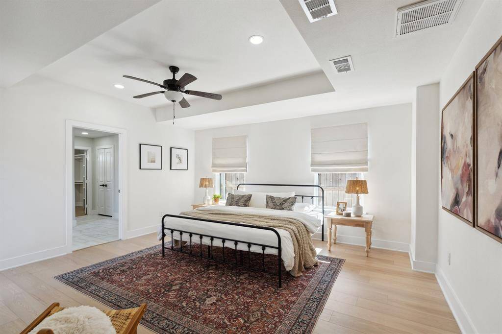 An airy primary suite with beautiful trayed ceilings and sunlight streaming in, perfect for unwinding.