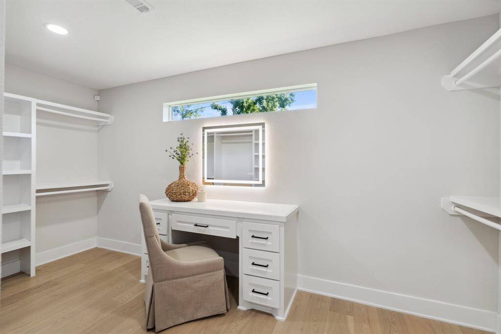 A built-in vanity is thoughtfully tucked into the generous walk-in closet.
