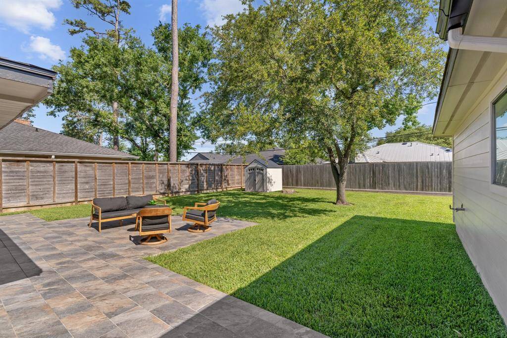 Step outside to the expansive custom-tiled back patio and lush backyard.