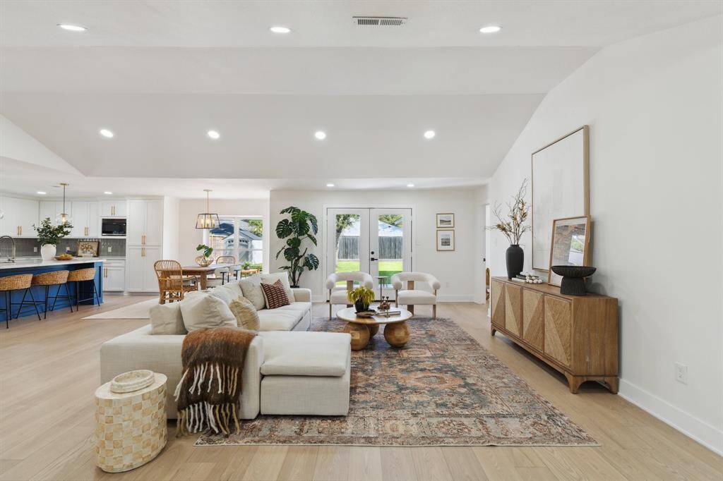 This spacious living area is enhanced by the cathedral ceilings and wide-plank white oak engineered hardwood floors.