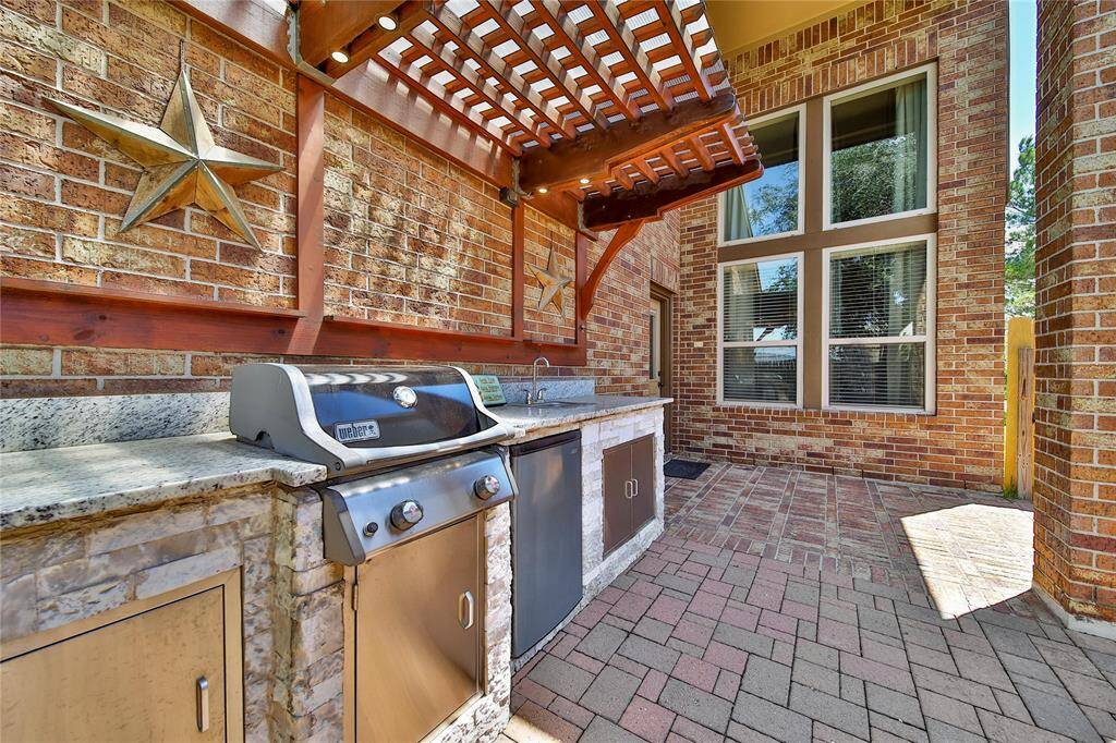 Pergola with outdoor grill and sink.