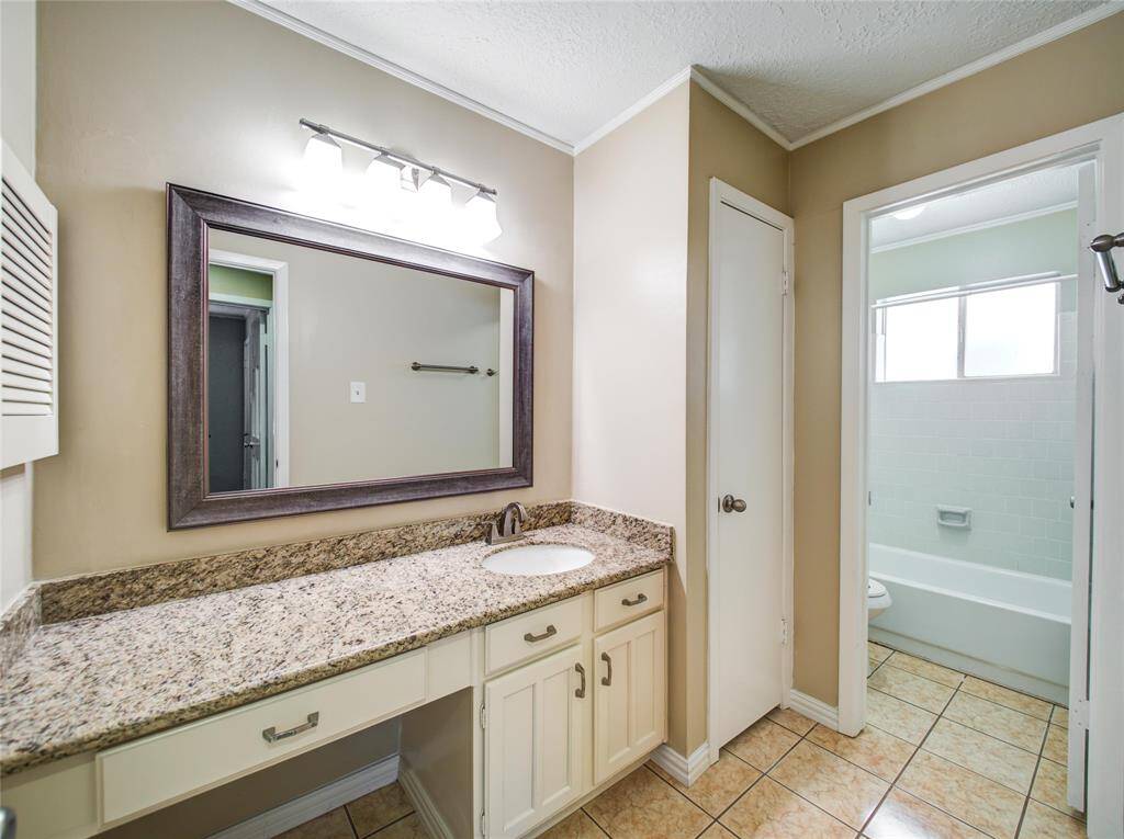 Well-appointed guest bath with granite countertop and separate tub.