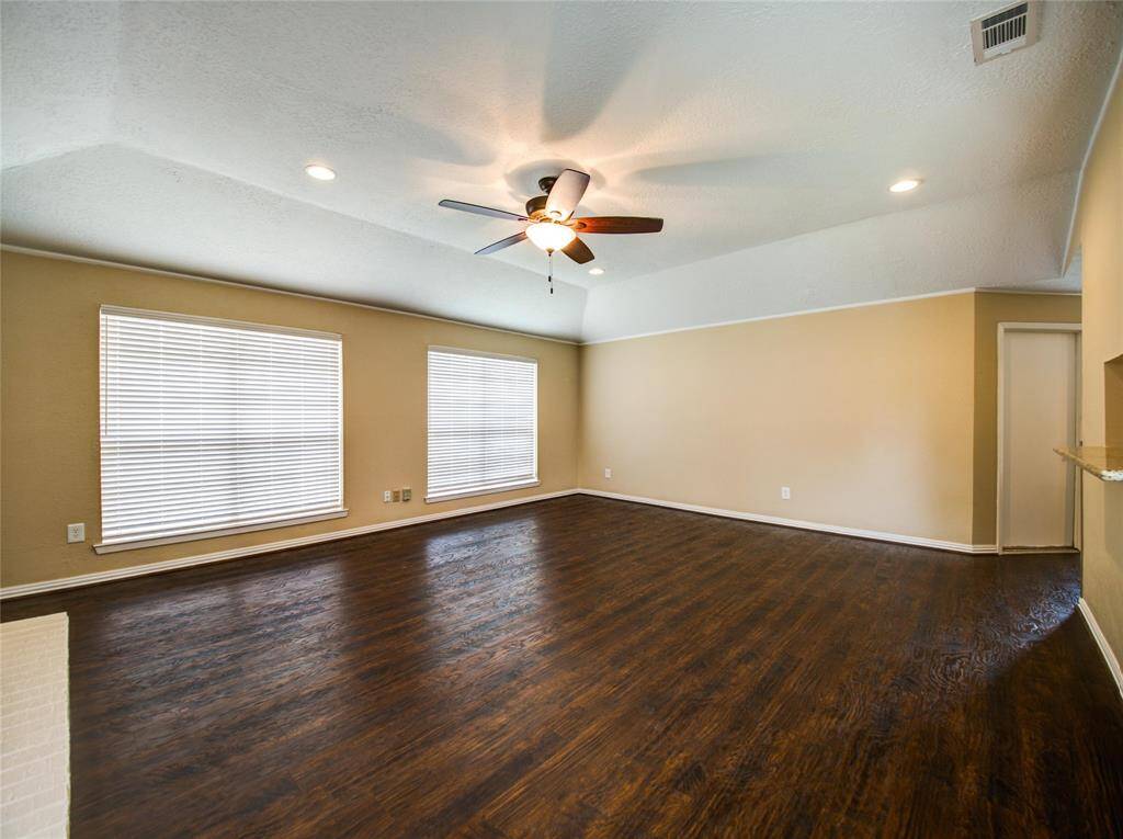 Another inviting living room view featuring a ceiling fan and bright, airy ambiance.
