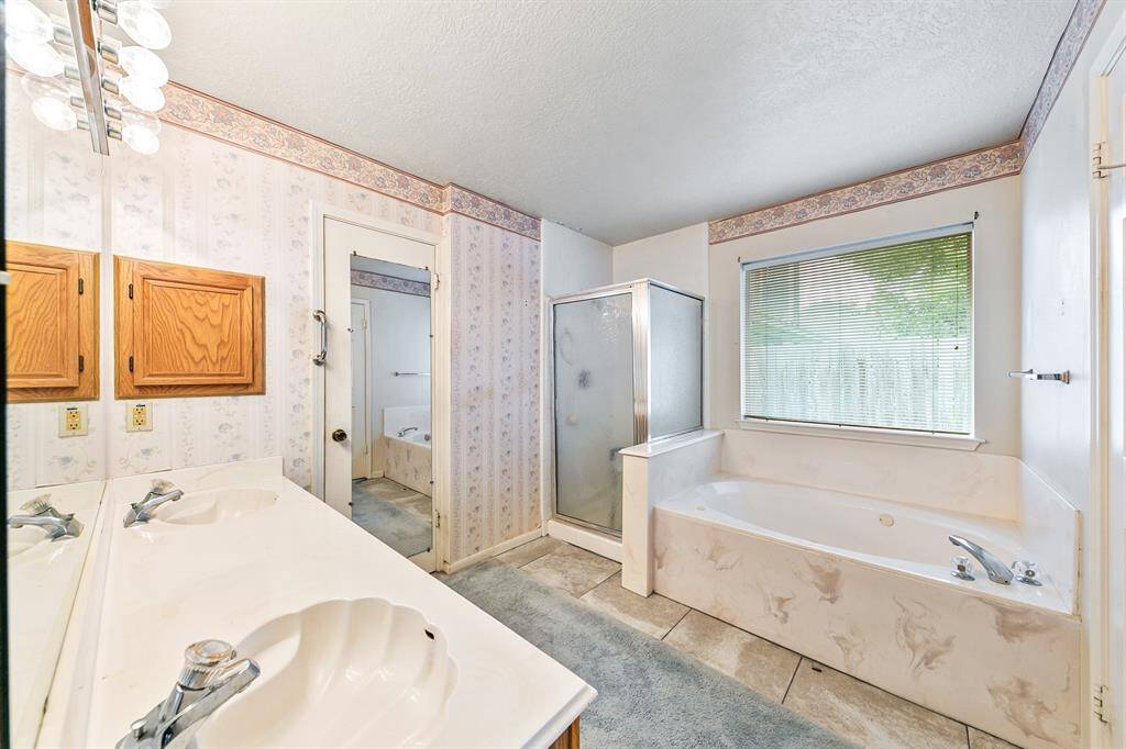 Features of the primary bathroom include dual sinks and a separate tub and shower. Previous photos from 2022 Prior to freeze