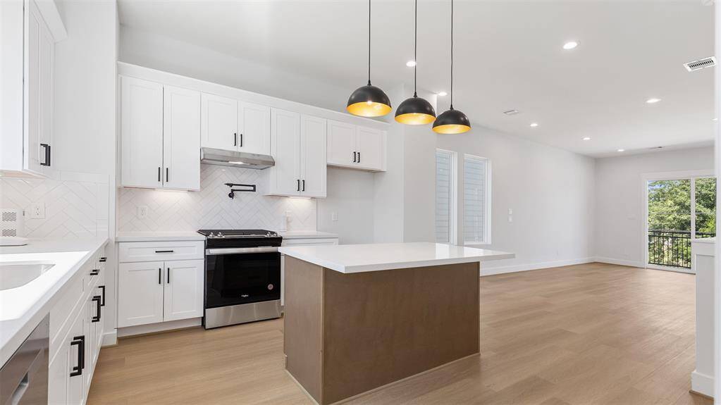 The kitchen features white cabinets,creating a clean and timelessaesthetic.