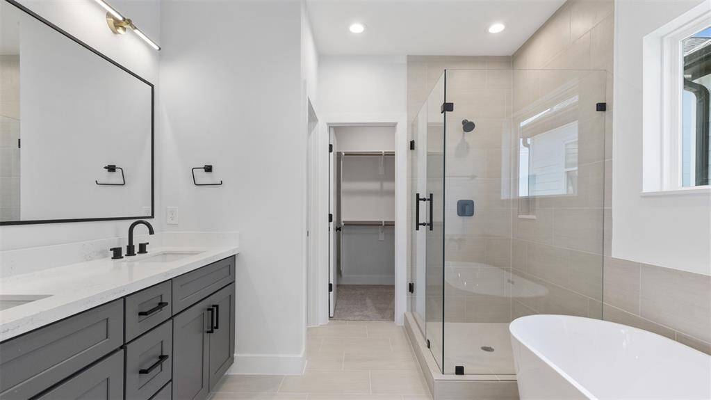 The primary bathroom features tile floors, dual sinks, walk-in shower, and soaking tub!