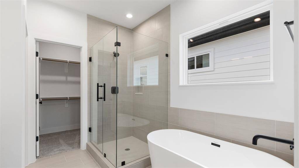 The primary bathroom features tile floors, dual sinks, walk-in shower, and soaking tub!