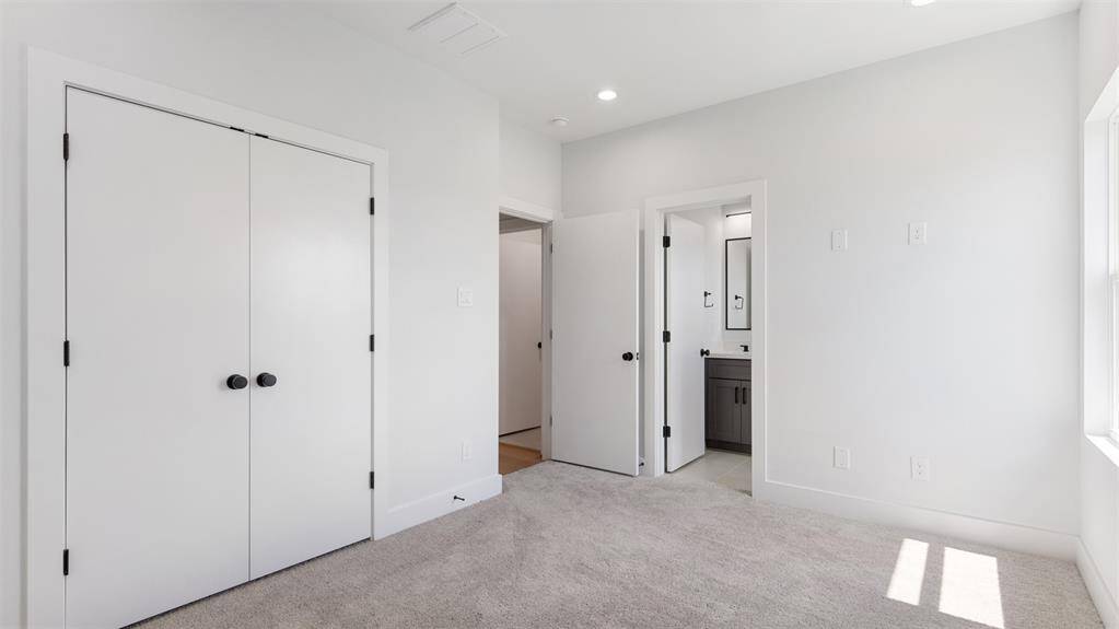 Secondary bedroom features awindow and plush carpet.