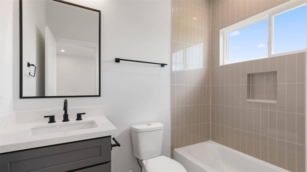 Secondary bathroom features atub/shower combo with tile surround.