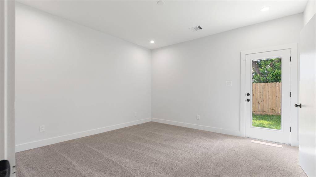 The first floor bedroom features plush carpet and access to the yard.