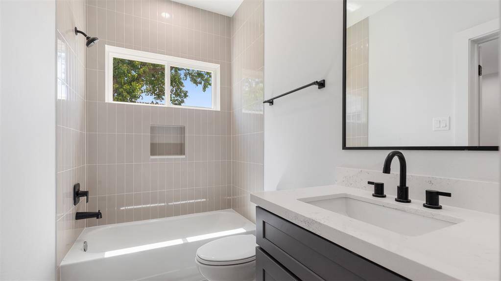 The first floor bathroom features a tub and shower combo with tile surround.