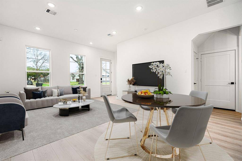 Light wood flooring adds warmth and sophistication, while the glass-paneled door invites guests and family to experience contemporary living at its finest in this beautifully crafted home!