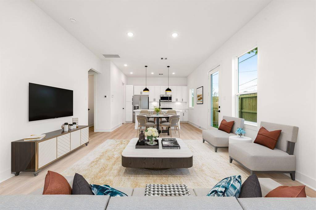 Step into modern elegance with this open-concept living space, where sleek design meets effortless comfort. The bright, airy interior is enhanced by recessed lighting, large windows, and a seamless flow between the kitchen, dining, and living areas. The gourmet kitchen boasts crisp white cabinetry, quartz countertops, stainless steel appliances, and a spacious island—perfect for entertaining.