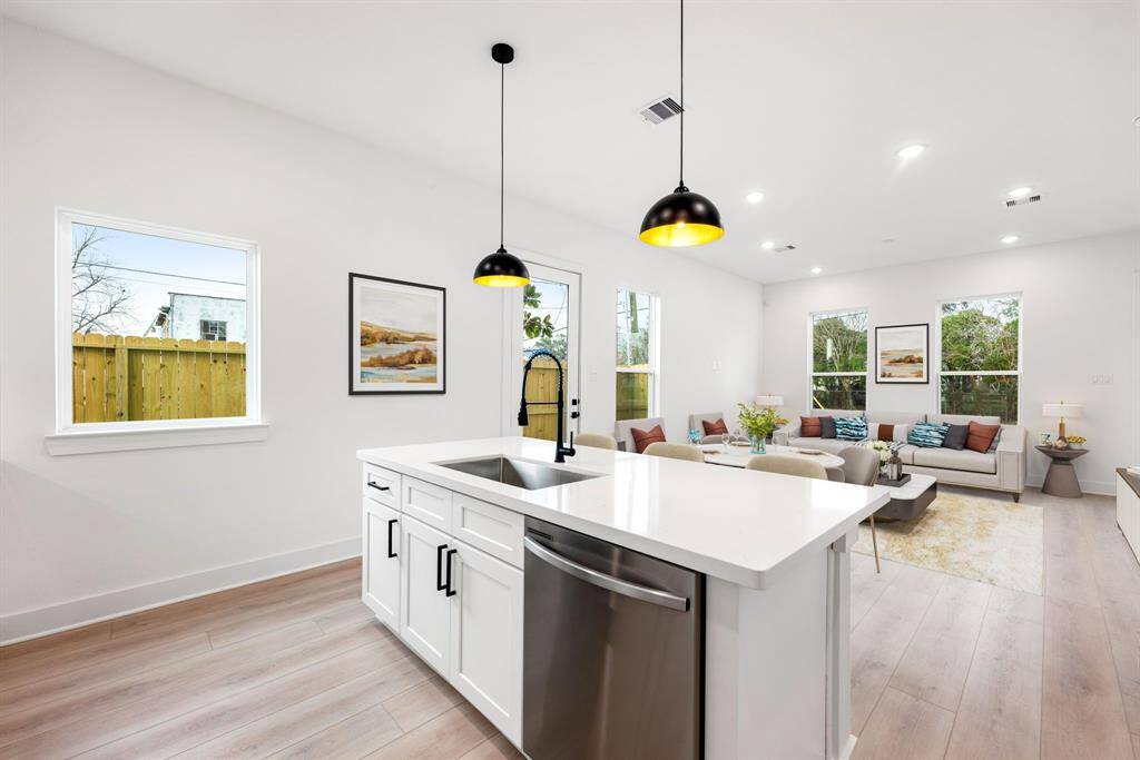 The seamless flow into the living area, complemented by large windows that flood the space with natural light, creates the perfect setting for entertaining and everyday living.