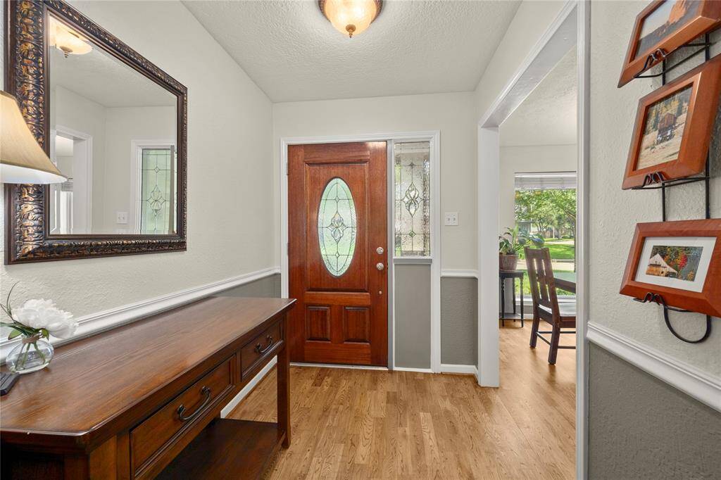 The recently refinished and stained wood flooring, freshly painted walls and ceiling along with the beautiful, leaded glass panels of the solid wood door and the sidelight have created an inviting place for your friends and family to be welcomed into your home.