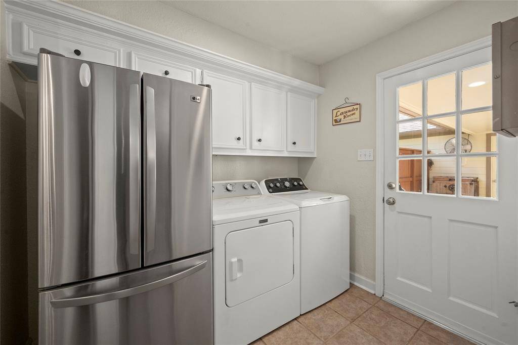This laundry room offers plenty of space for your large refrigerator, washer and dryer.  Notice the amount of storage you have above the appliances.  This door leads to the back patio, yard and pool.  The 1/2 bath is located just behind us.