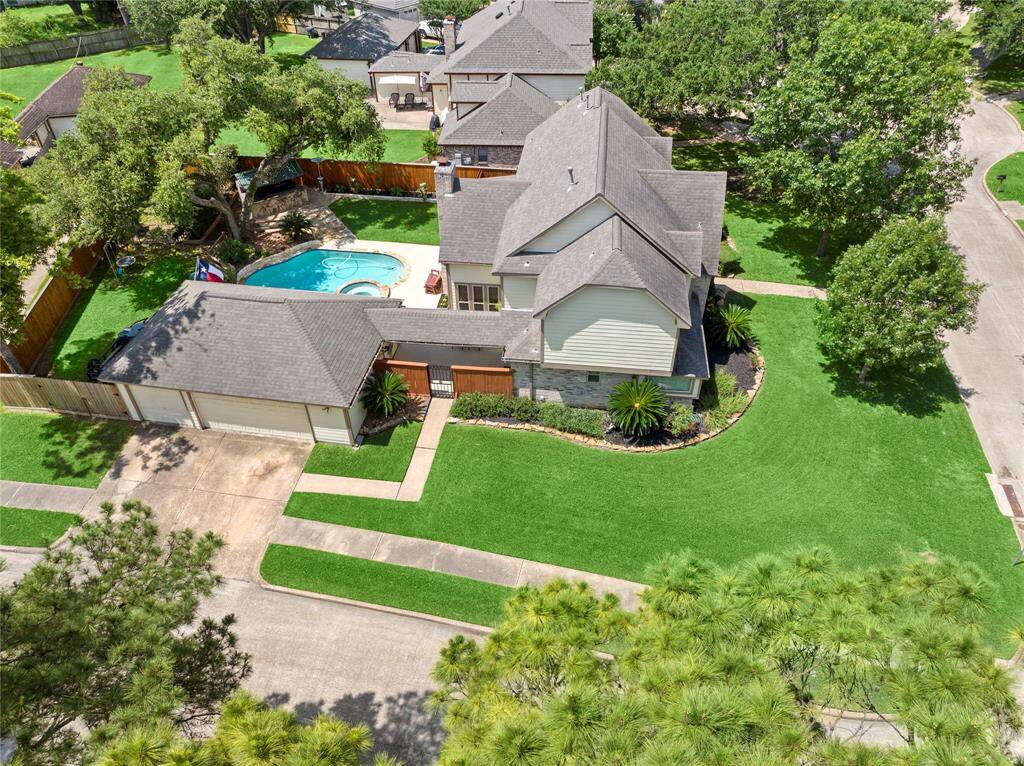 Nestled in the middle of this quiet neighborhood with mature trees throughout is this spectacular property. This view allows you to see its meticulously manicured lawn, stone-lined flowerbeds, majestic oaks, pristine home and backyard with its gorgeous pool and spa and a flagstone path leading to a poolside smoke or grill house.