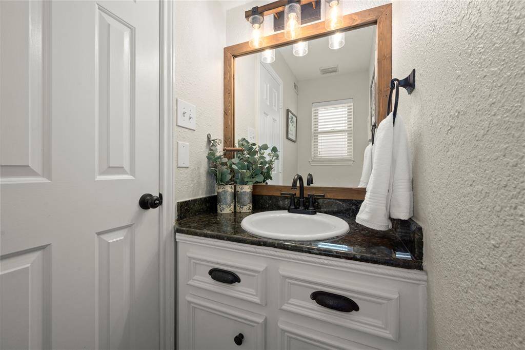 This super spacious 1/2 bath has granite countertops, updated porcelain sink, faucet, mirror, hardware and lighting fixture.  The toilet was also recently replaced.