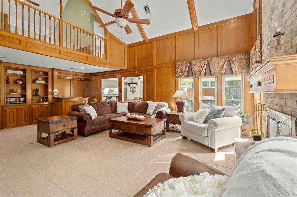 From this view you can see how spacious the family room really is.  Notice the built-in shelves and cabinets under the gameroom balcony. Next to the built-ins is the wet bar. What a perfect spot to make your family or friends a drink or serve them some wine that had been chilling in the wine fridge below.