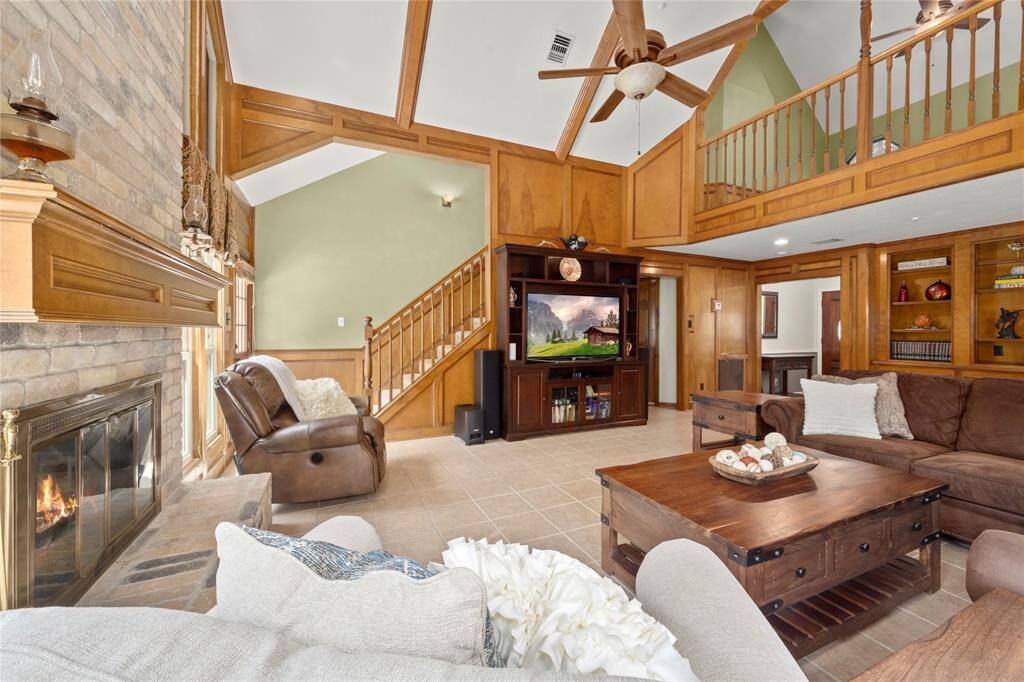 As you sit in this sunny corner of the family room, you can see the stairway leading to the upstairs gameroom, balcony, 3 bedrooms and 2 full bathrooms. Also visible is the entry into the primary suite located between the entertainment center and the foyer.
