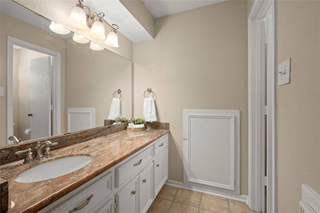 This is one of 2 secondary bathrooms.  It has this attractive granite countertop with an undermounted sink, recent hardware, plumbing and light fixtures.  The cabinetry offers a ton of storage!