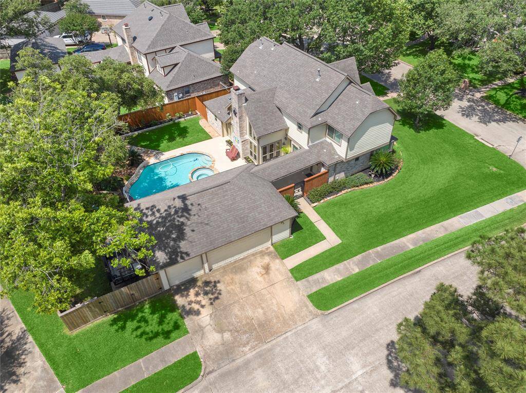 This is a great view of the double gate hiding the trailer parked on its concrete pad.  It also shows the oversized 3 car garage, a triple driveway, the area on the other side of the house that has a fenced yard for the ac units and pool equipment.