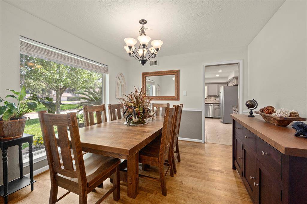 When your guests enter the foyer, they are greeted by this expansive dining room with handsome wood floors, 6-globed chandelier, freshly painted walls and ceiling and the huge window that permits visitors to experience the beauty of your property.