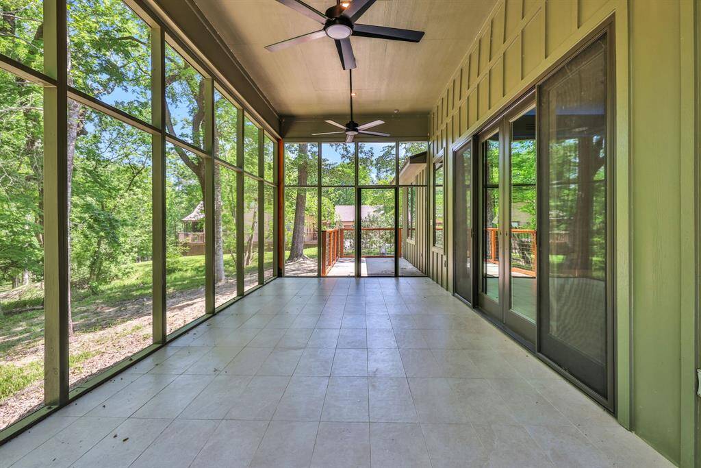 Expansive screened-in porch with dual ceiling fans offering a peaceful, bug-free retreat to enjoy the outdoors year-round.