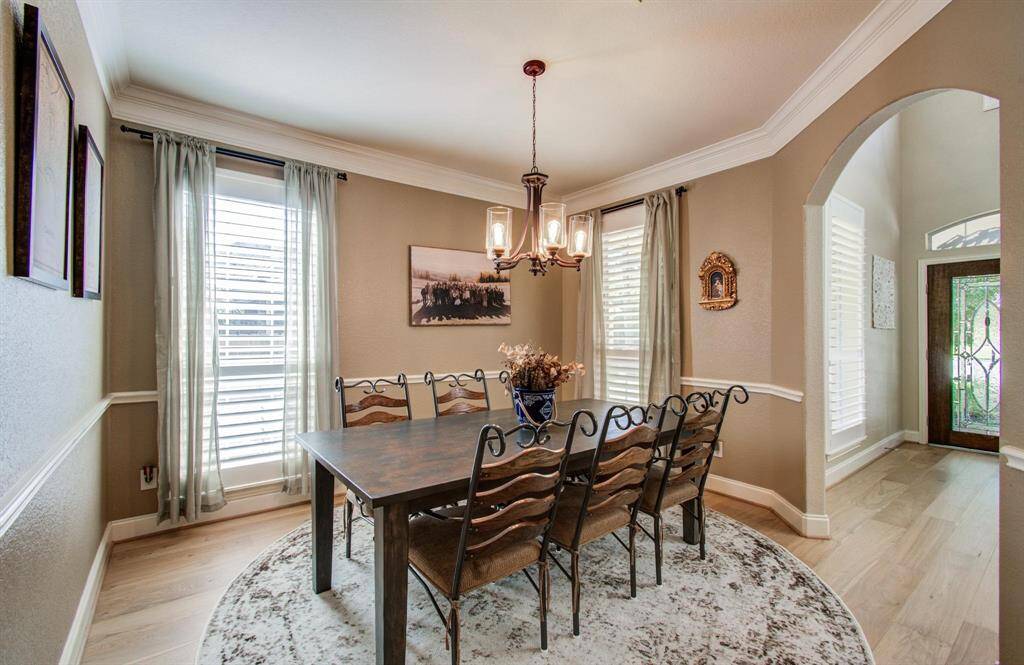 A stunning dining room with large windows and crown molding.